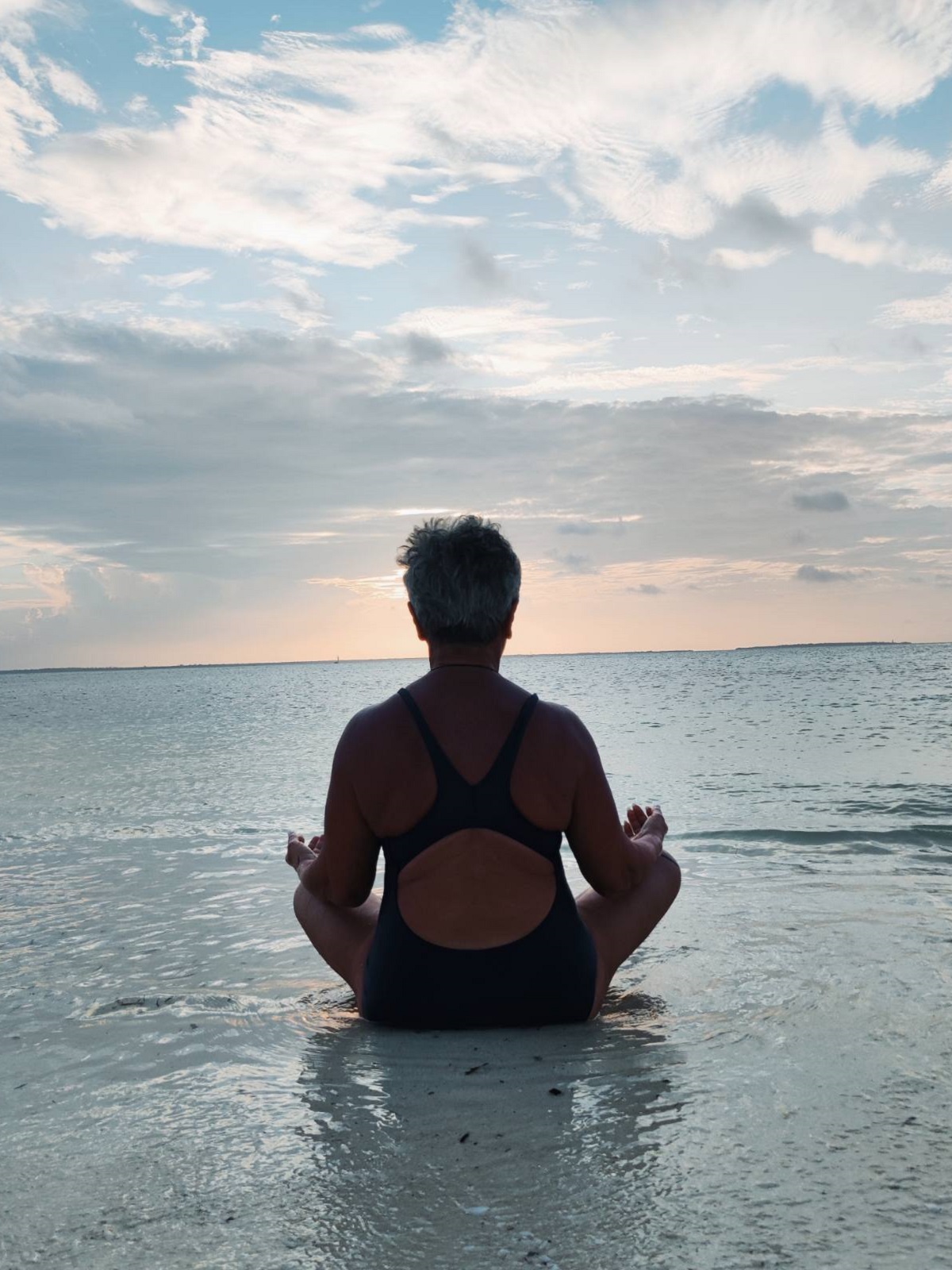 woman doing yoga by the sea